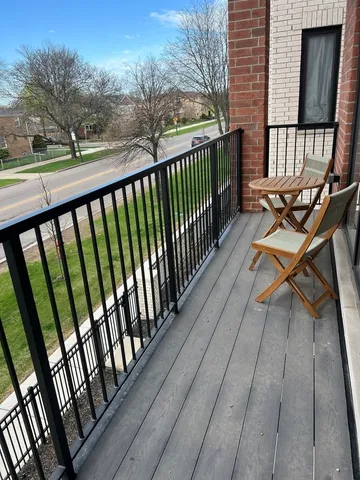 a view of balcony with wooden floor and bench
