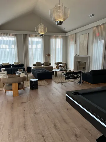 a living room with furniture a large window and a chandelier