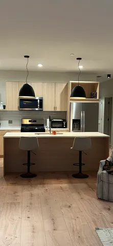 a kitchen with kitchen island granite countertop a stove and a refrigerator