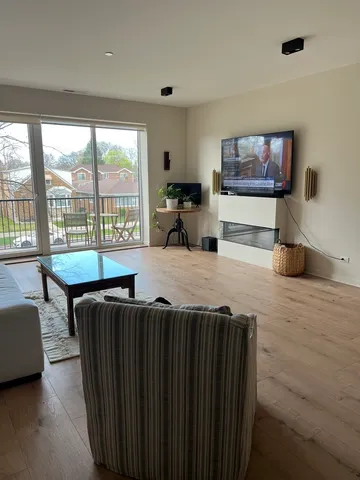 a living room with furniture a flat screen tv and floor to ceiling window