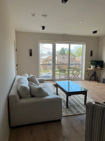 a living room with furniture a table and a floor to ceiling window
