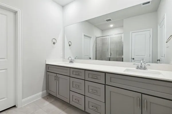 a bathroom with double sink and a mirror