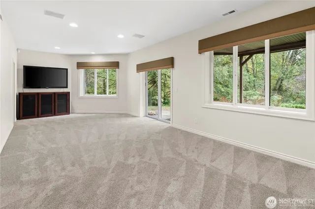 a view of an empty room with a window and fire place