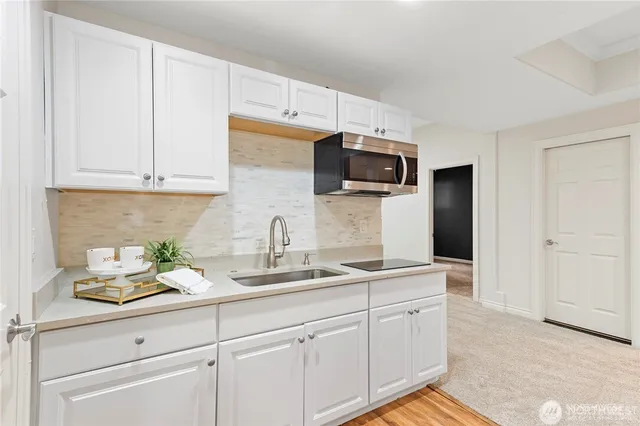 a kitchen with appliances a sink and cabinets