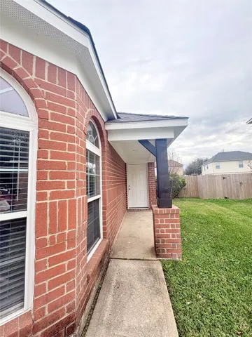 a view of yard with swimming pool and brick wall