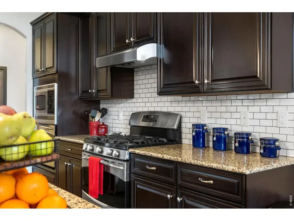 a kitchen with granite countertop a stove and cabinets