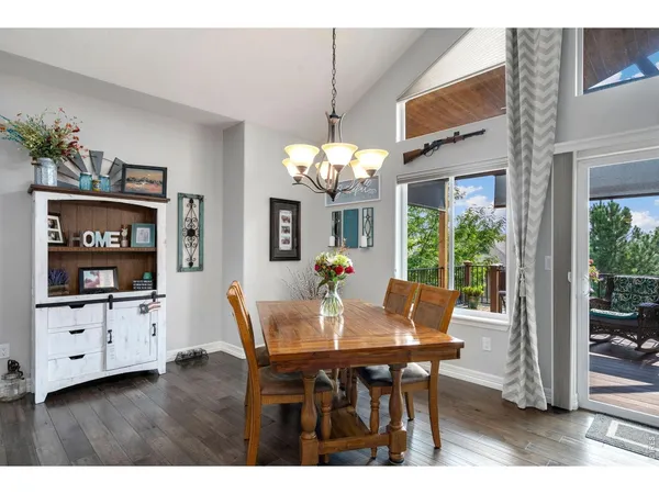 a dining room with furniture potted plants and wooden floor