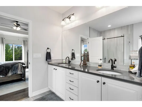 a spacious bathroom with double vanity a sink a mirror and a shower