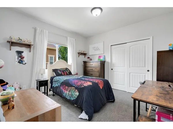 a bedroom with a bed and large windows