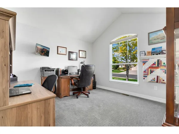 a view of a workspace with furniture and a window