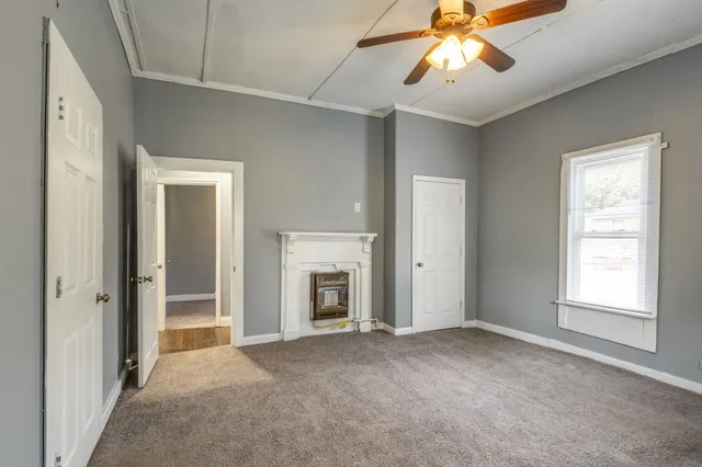 a view of a livingroom with a chandelier fan and a fireplace
