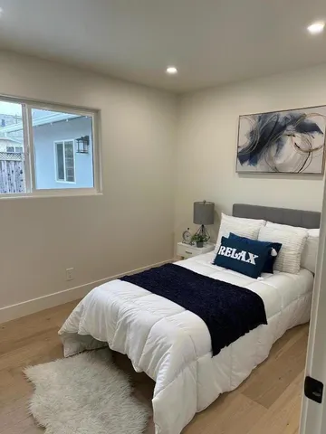 a bedroom with a bed and painting on the wall