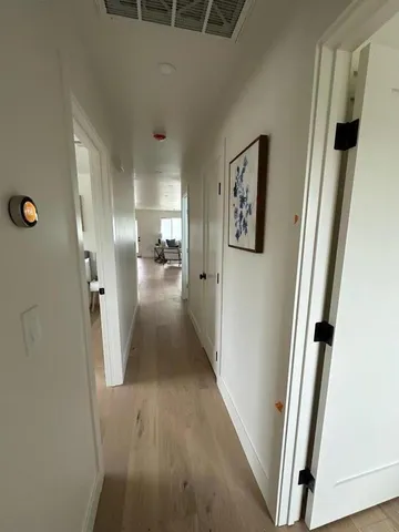 a view of a hallway with wooden floor and stairs