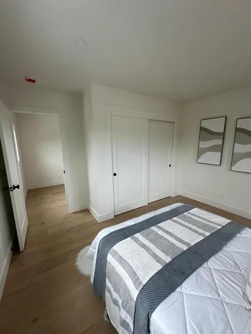 a bedroom with a bed and painting on the wall