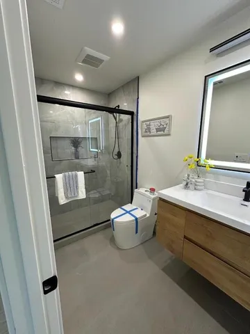 a bathroom with a sink mirror and a shower