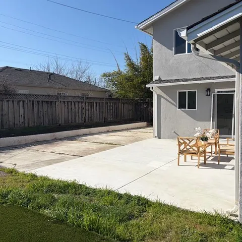 a backyard of a house with table and chairs