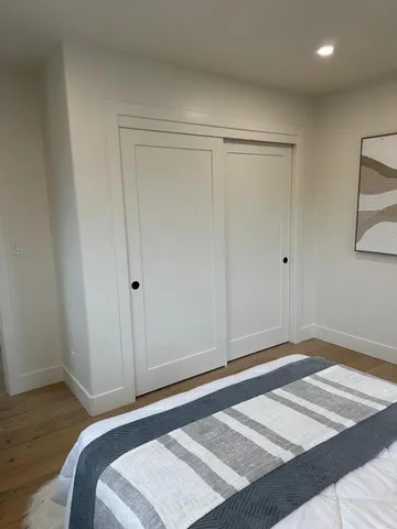 a bedroom with a bed and wooden floor