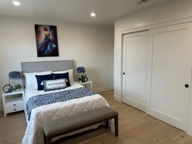 a bedroom with a bed and a painting on the wall