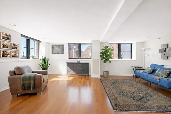 a living room with furniture and wooden floor