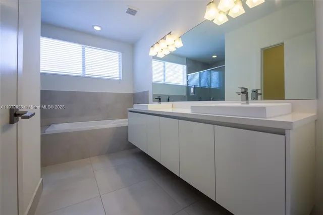 a bathroom with a tub sink and mirror