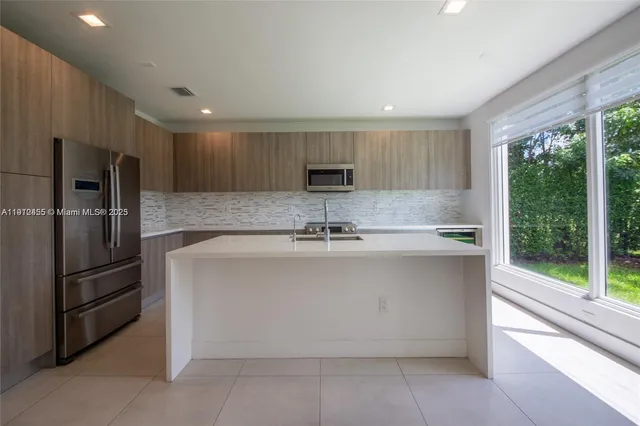 a view of a kitchen with a sink and a refrigerator