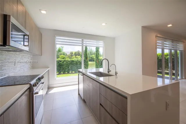 a kitchen with stainless steel appliances granite countertop sink stove and refrigerator