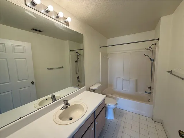 a bathroom with a sink a toilet a mirror and shower