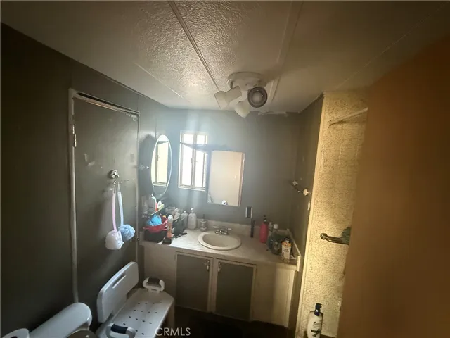 a bathroom with a sink mirror vanity and toilet