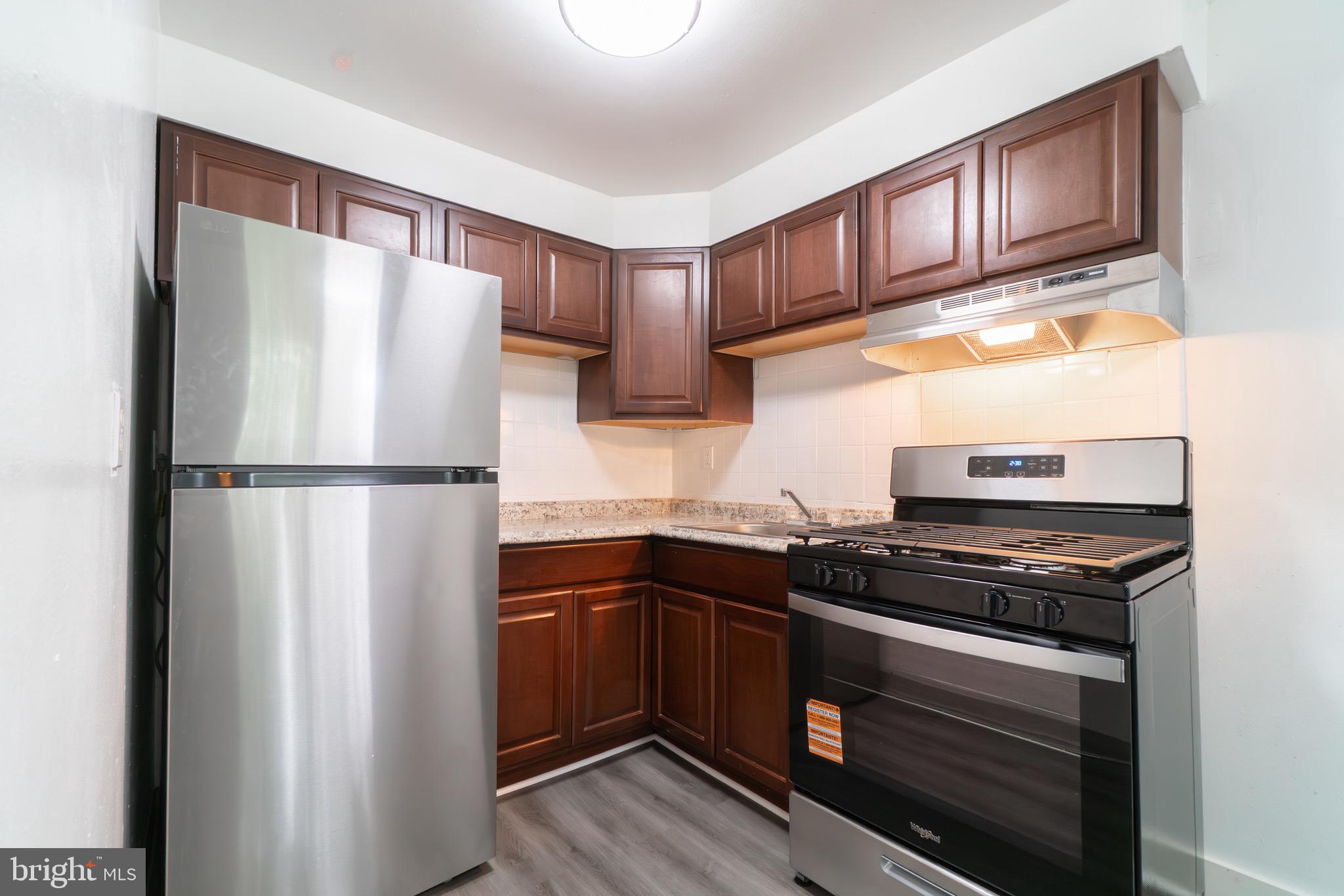 4616 Leiper Street, Unit D11 Philadelphia, PA 19124 - Photo 4 of 11 a kitchen with stainless steel appliances granite countertop a refrigerator stove top oven a sink and dishwasher