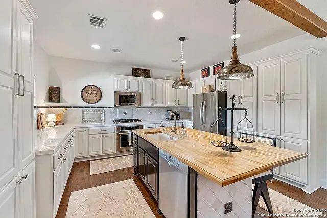 a kitchen with a sink a stove and chairs