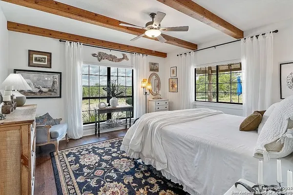 a bedroom with a bed next to a window and a flat screen tv