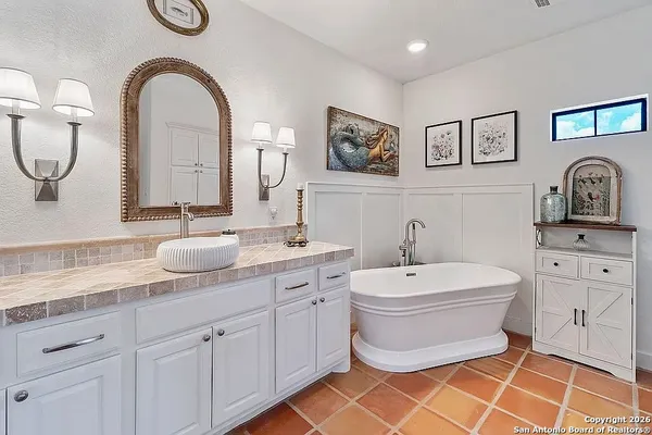 a spacious bathroom with a toilet a sink and a mirror