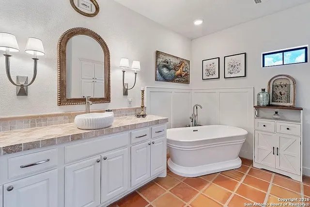 a spacious bathroom with a toilet a sink and a mirror