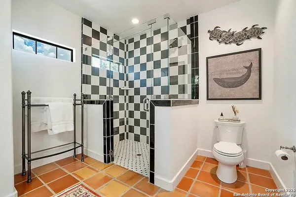 a bathroom with a toilet and a shower