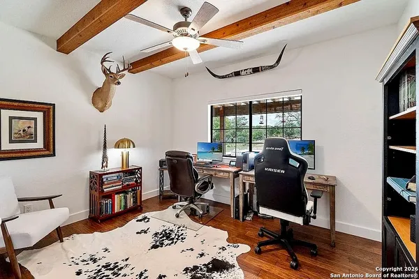 a view of a workspace with furniture and a window