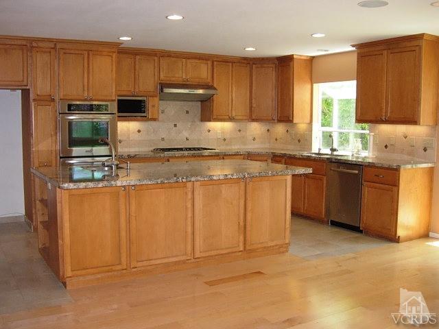 2120 Outsail Lane Oxnard, CA 93035 - Photo 2 of 24 a kitchen with kitchen island granite countertop stainless steel appliances a sink a stove top oven a counter space and cabinets