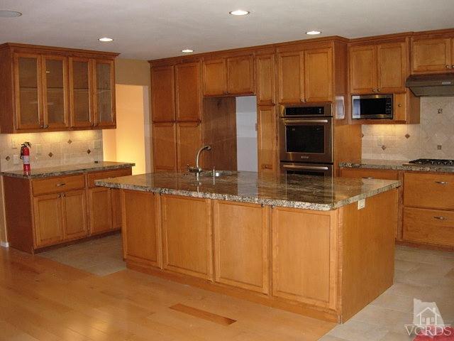 2120 Outsail Lane Oxnard, CA 93035 - Photo 3 of 24 a kitchen with kitchen island granite countertop a sink counter top space appliances and cabinets