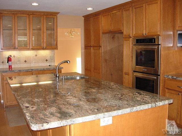 2120 Outsail Lane Oxnard, CA 93035 - Photo 4 of 24 a kitchen with kitchen island granite countertop a sink stove and refrigerator
