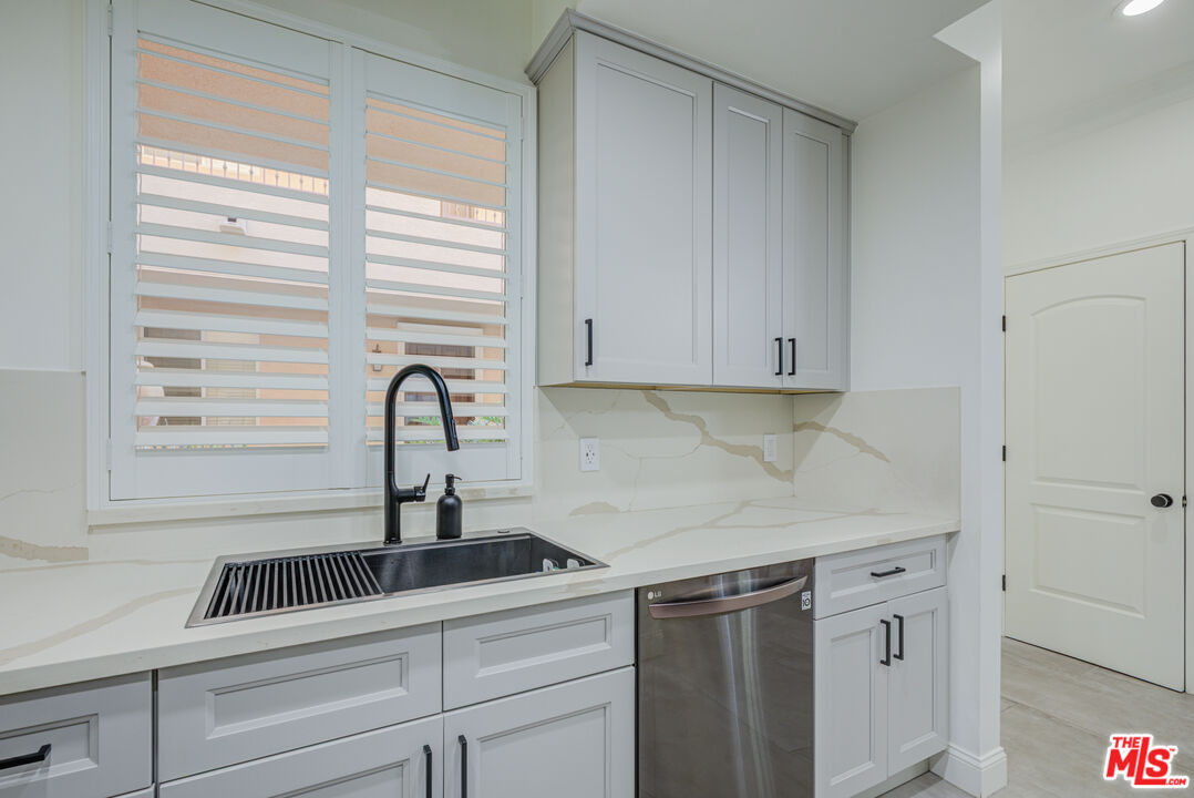 1444 South Point View Street, Unit 103 Los Angeles, CA 90035 - Photo 30 of 44 a kitchen with white cabinets and a sink