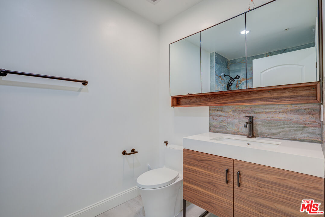 1444 South Point View Street, Unit 103 Los Angeles, CA 90035 - Photo 42 of 44 a bathroom with a sink a toilet and mirror