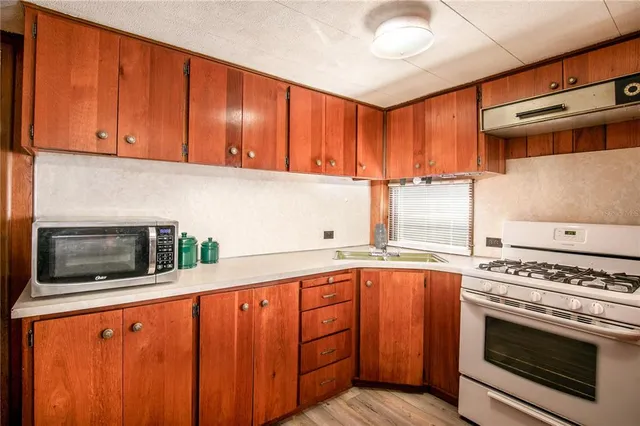 a kitchen with stainless steel appliances wooden cabinets and a stove top oven