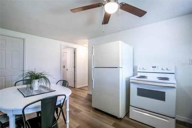 a kitchen with appliances cabinets and wooden floor