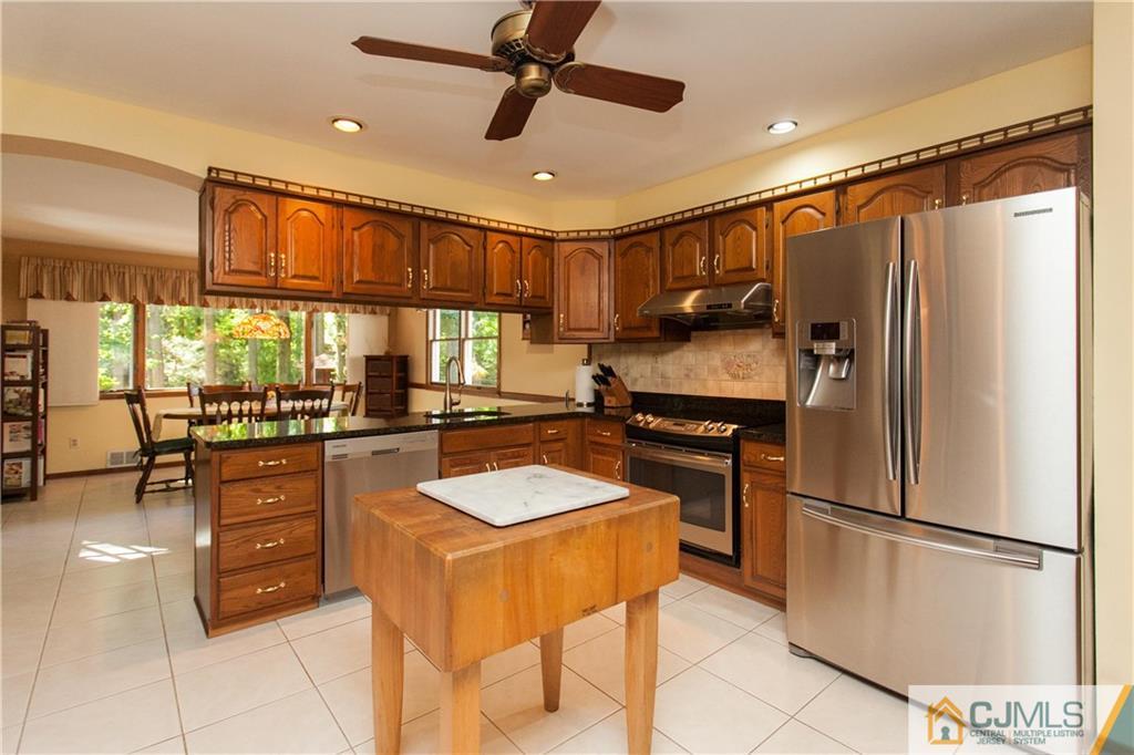 18 Huntington Road Edison, NJ 08820 - Photo 4 of 21 a kitchen with a refrigerator a sink and chairs