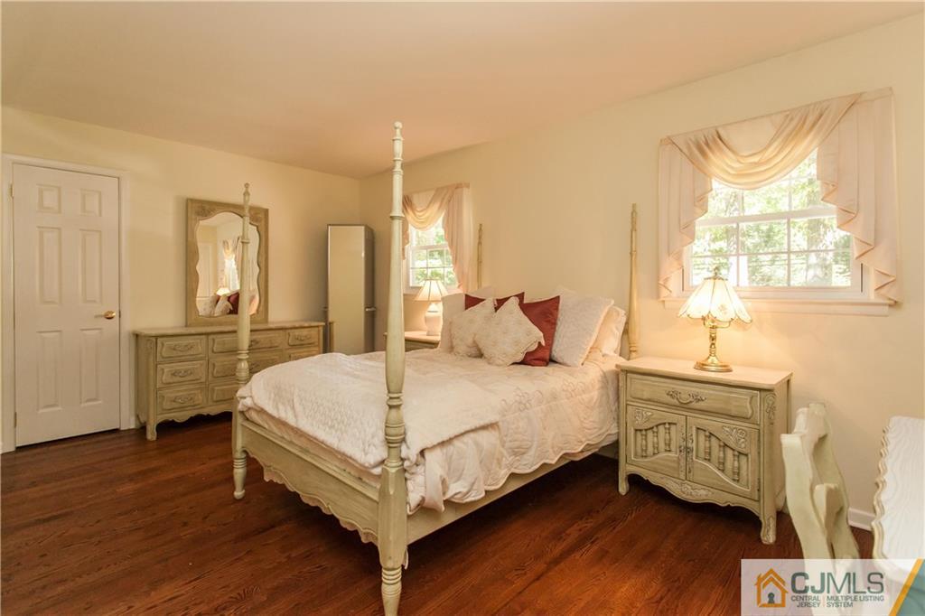 18 Huntington Road Edison, NJ 08820 - Photo 8 of 21 a bedroom with a bed a mirror on dresser and a wooden floor