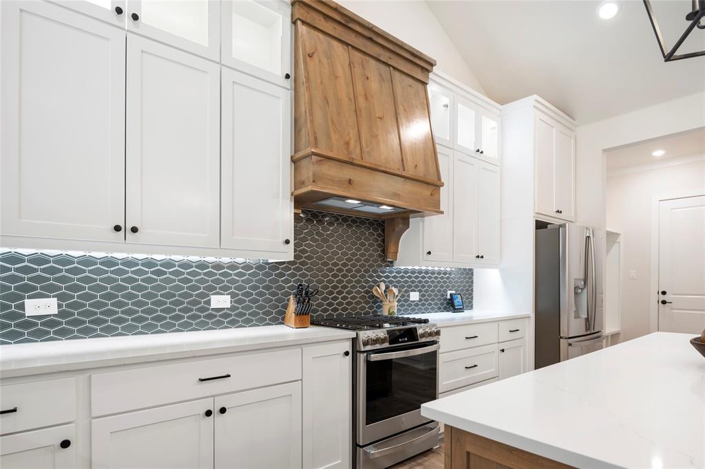 704 Abbey Road Van Alstyne, TX 75495 - Photo 11 of 38 a kitchen with stainless steel appliances a stove a sink and a refrigerator