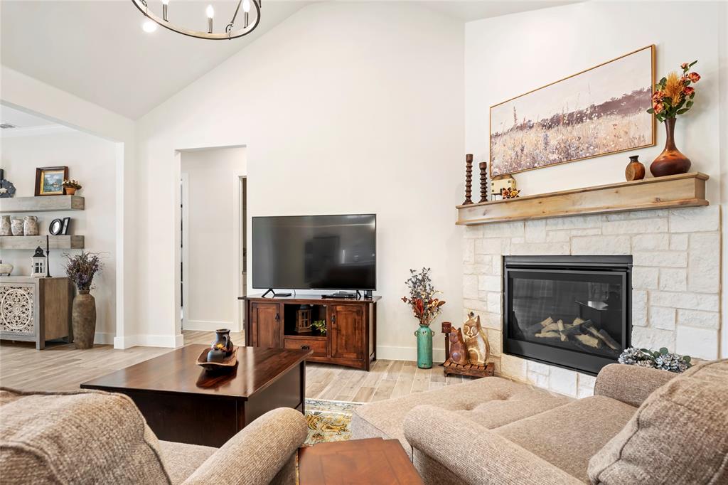 704 Abbey Road Van Alstyne, TX 75495 - Photo 15 of 38 a living room with furniture a flat screen tv and a fireplace