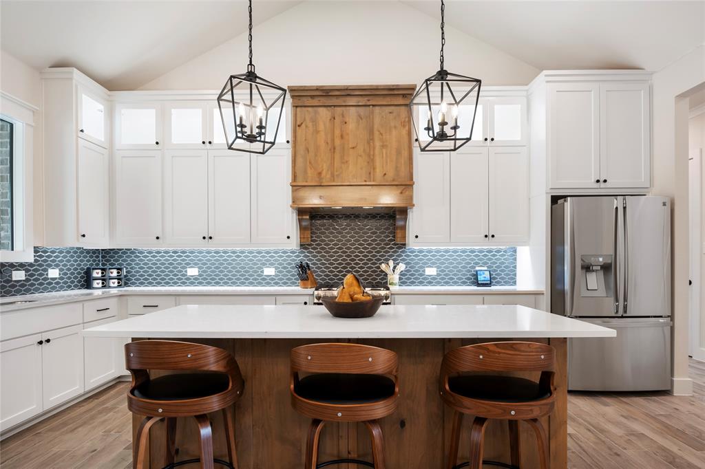 704 Abbey Road Van Alstyne, TX 75495 - Photo 8 of 38 a kitchen with stainless steel appliances granite countertop a sink a stove and chairs