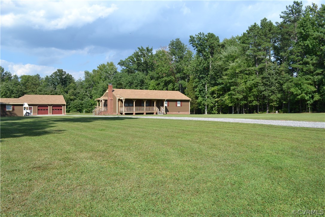 a front view of house with yard and trees in the background