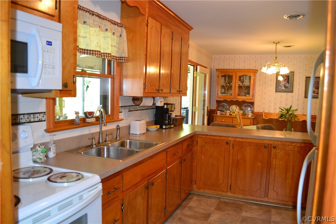 9711 Beaver Bridge Road Chesterfield, VA 23838 - Photo 15 of 24 a large kitchen with stainless steel appliances a large counter top a stove and a sink