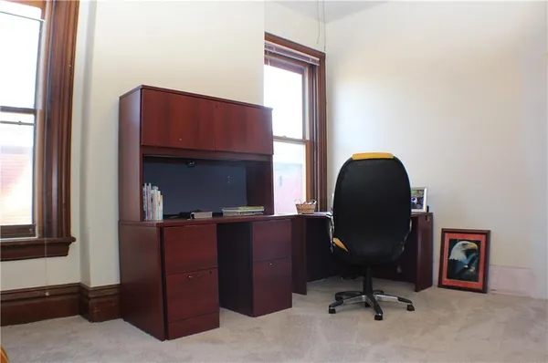 a view of a workspace with furniture and a window